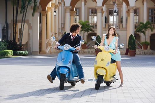 Couple sitting on mopeds, Biltmore Hotel, Coral Gables, Florida, USA