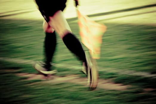 Low section view of a lineman running with a flag