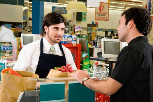 Sales clerk selling products to a costumer in a supermarket