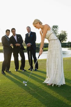 Bride playing golf and three men watching her, Biltmore Golf Course, Coral Gables, Florida, USA