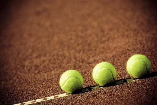 Close_up of three tennis balls in a court