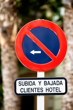 Close_up of a no parking sign with an arrow sign