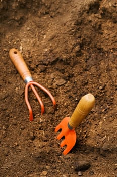 Gardening fork and rake in compost
