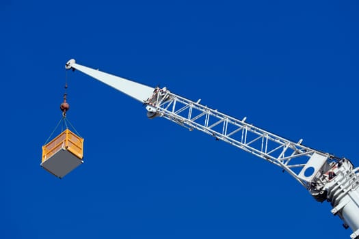 Low angle view of a crane picking up a box
