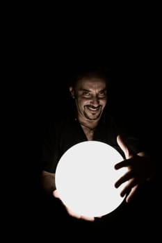 Portrait of a man holding a crystal ball and smiling