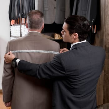 Tailor taking the measurements of a customer
