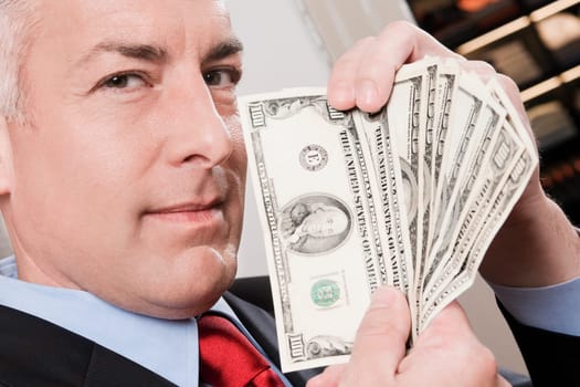 Businessman holding currency notes in a clothing store