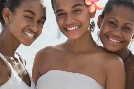 Portrait of three female friends smiling on the beach