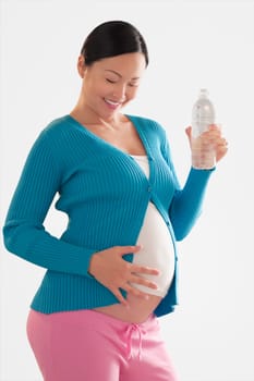Pregnant woman touching her abdomen and smiling