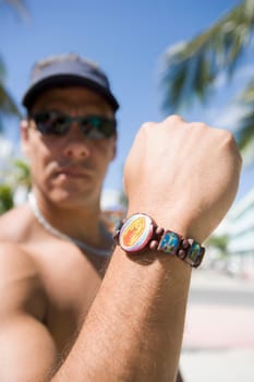 Close_up of a mature man showing a bracelet