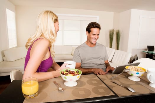 Couple having breakfast and using a laptop