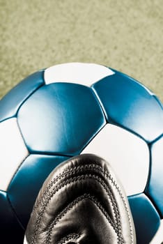 Close_up of a soccer ball with a sports shoe