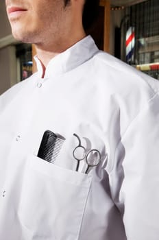 Close_up of a barber with scissors and a comb in his pocket