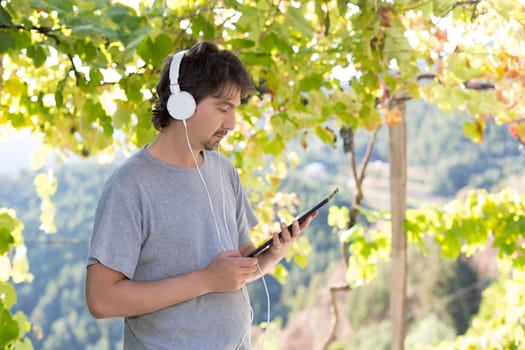 Young man relaxing with a tablet computer at a garden