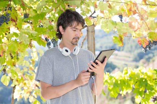 Young man relaxing with a tablet computer at a garden