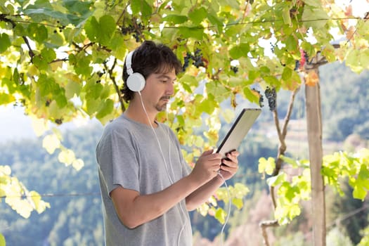 Young man relaxing with a tablet computer at a garden