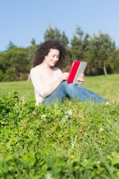 A beautiful young woman relaxing at the city park - Selective focus on the grass