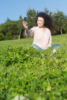 A beautiful young woman relaxing at the city park - Selective focus on the grass