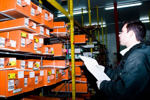 Man examining flower boxes in a warehouse, Miami, Florida, USA