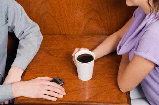 Mid section view of a couple sitting in a cafe
