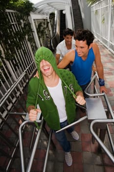 High angle view of three young men standing in front of an escalator