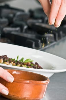 Woman sprinkling cilantro to beans