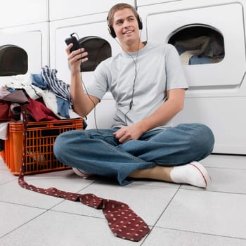 Man listening to an MP3 player in a laundromat