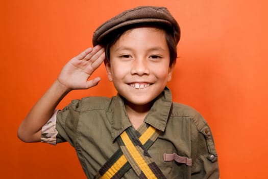 Close_up of a boy saluting