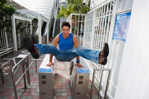Young man jumping over the ticket barriers