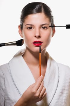Portrait of a young woman applying make_up