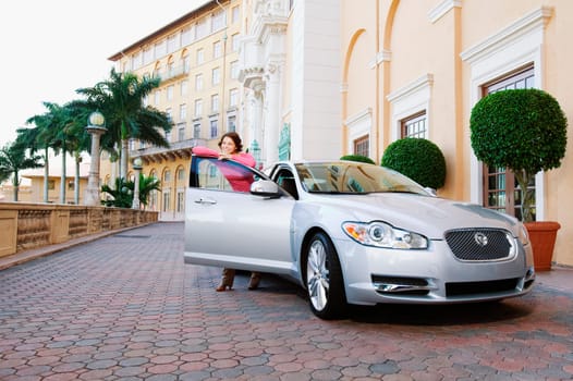Woman leaning against a car door and smiling, Biltmore Hotel, Coral Gables, Florida, USA
