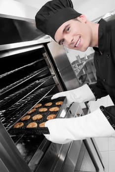 Chef taking out a tray of cookies from an oven