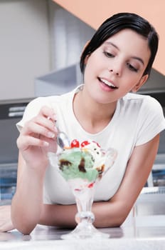 Teenage girl eating an ice cream in an ice cream parlor