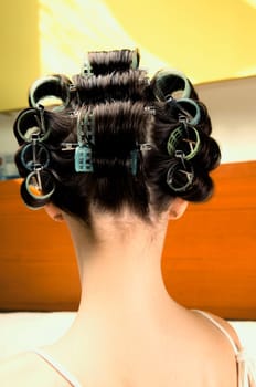 Rear view of a young woman wearing hair rollers