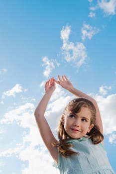 Low angle view of a girl with her arms raised