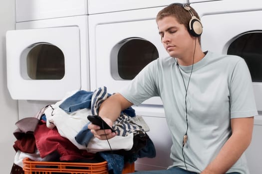 Man listening to an MP3 player in a laundromat