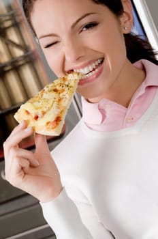 Female chef eating a slice of pizza