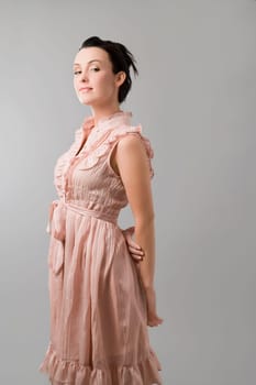 Portrait of a young woman standing with her hands behind her back