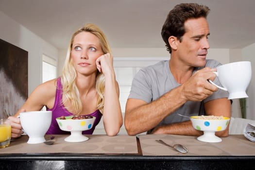 Couple ignoring each other at breakfast