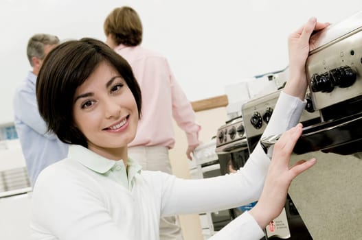 Female sales clerk showing a gas range