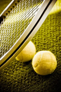 Close_up of a tennis racket and tennis balls in a court