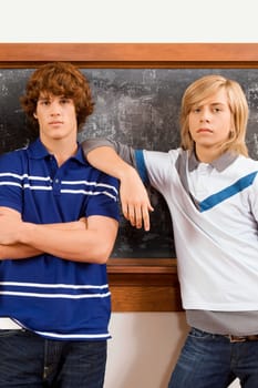 Two teenage boys standing in front of a blackboard
