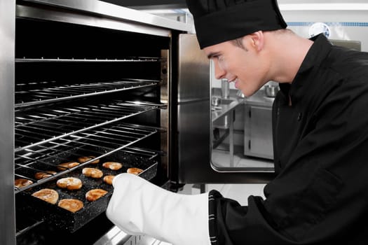 Chef taking out a tray of cookies from an oven