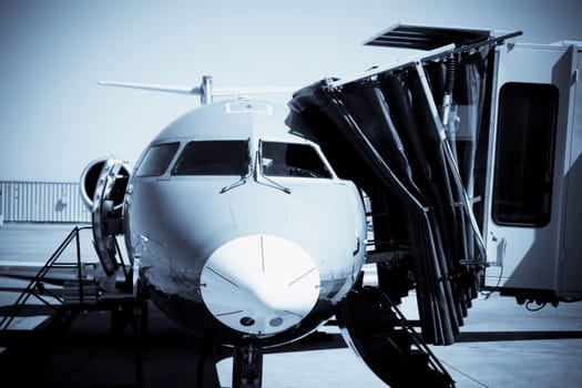 Airplane attached to passenger boarding bridge at an airport