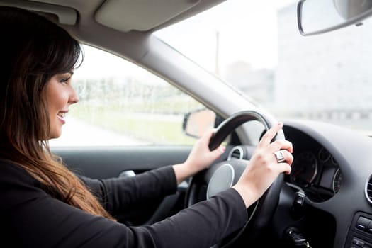 Business woman driving her new sports car