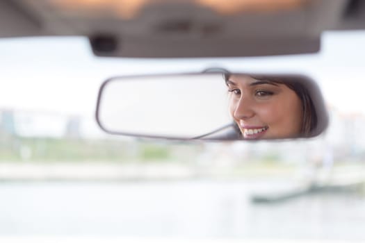 Happy woman driving - reflex in the mirror