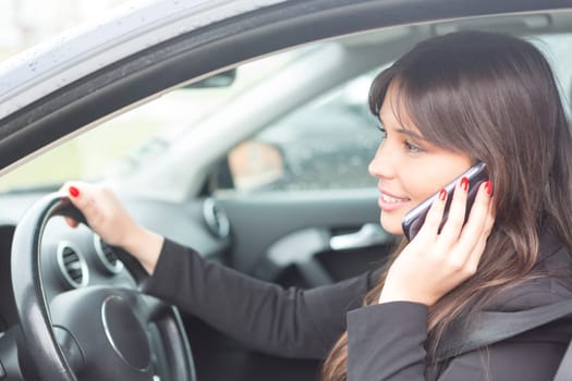 Business woman at the phone while driving