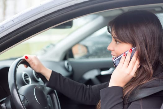 Business woman at the phone while driving