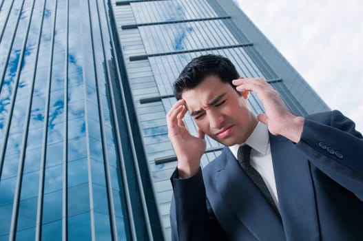 Low angle view of a businessman suffering from a headache