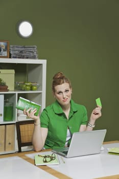 Businesswoman working on a laptop in the office and holding a credit card